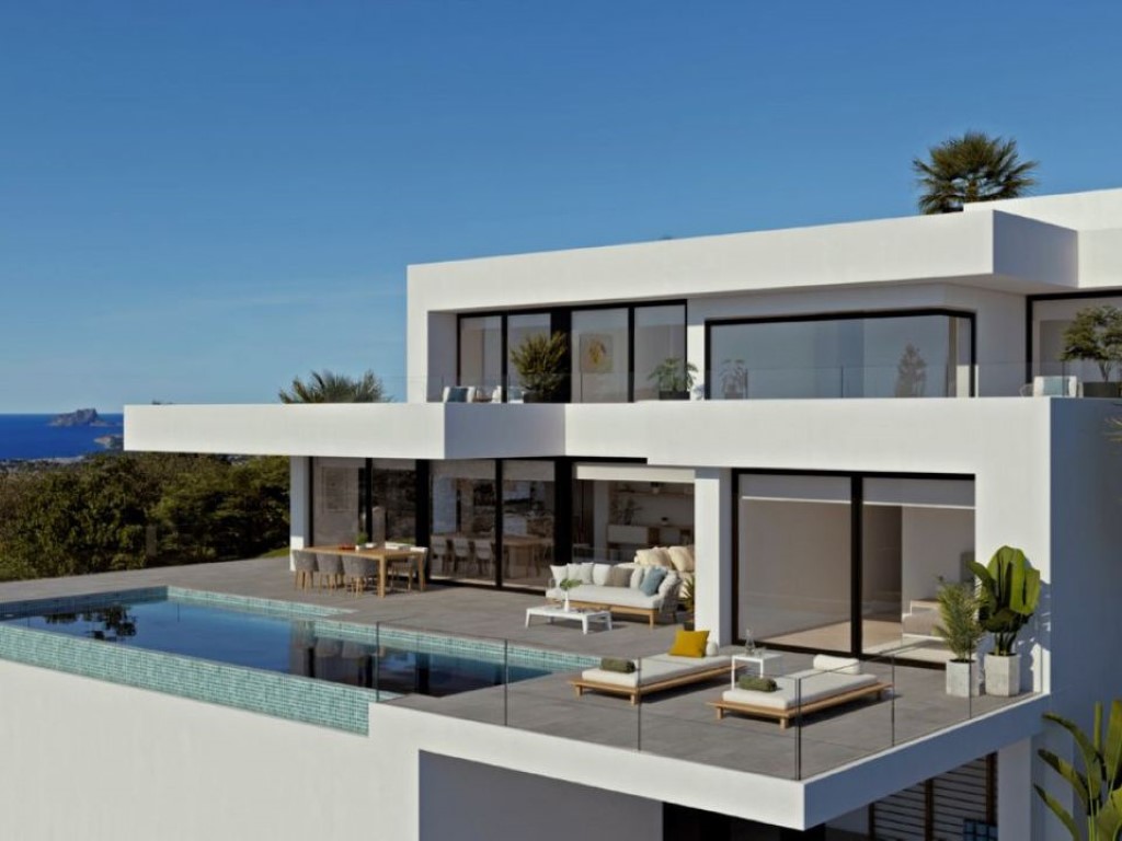 Modern white villa featuring an infinity pool with turquoise tiling and a spacious terrace. Large black-framed windows offer seamless indoor-outdoor living with sea views.