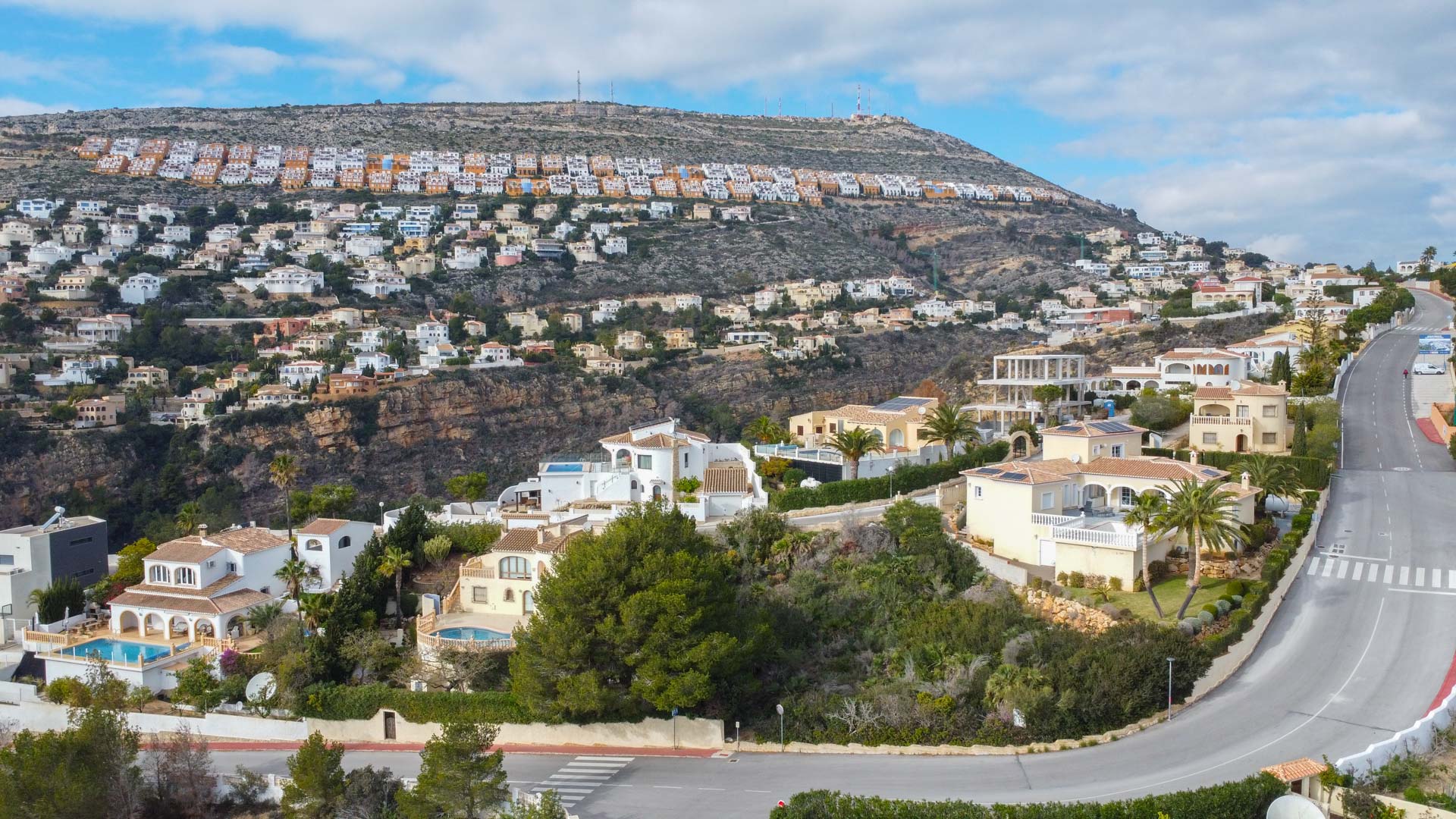 Panoramic aerial view of the Cumbre del Sol residential area, showing the hillside villa layout and Mediterranean landscape.