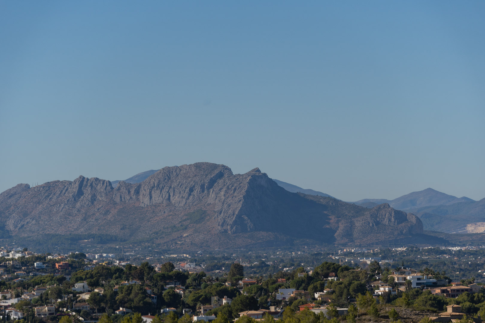 Panoramic views of the Montgó mountain range and the surrounding residential landscape of Denia under a clear blue sky.