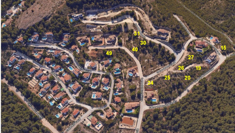 Aerial overview of the Jávea development, detailing numbered building plots integrated into a wooded hillside with paved roads and existing villas.