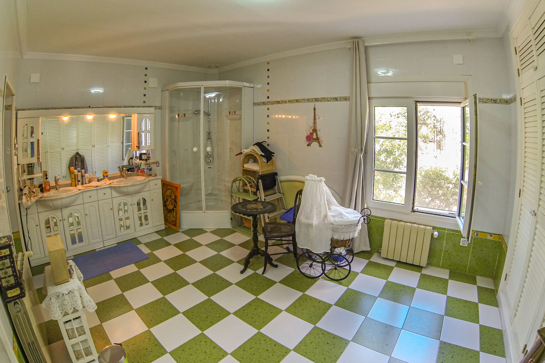 Bathroom featuring green and white checkered tile flooring, a corner shower, and a double vanity with white cabinetry.