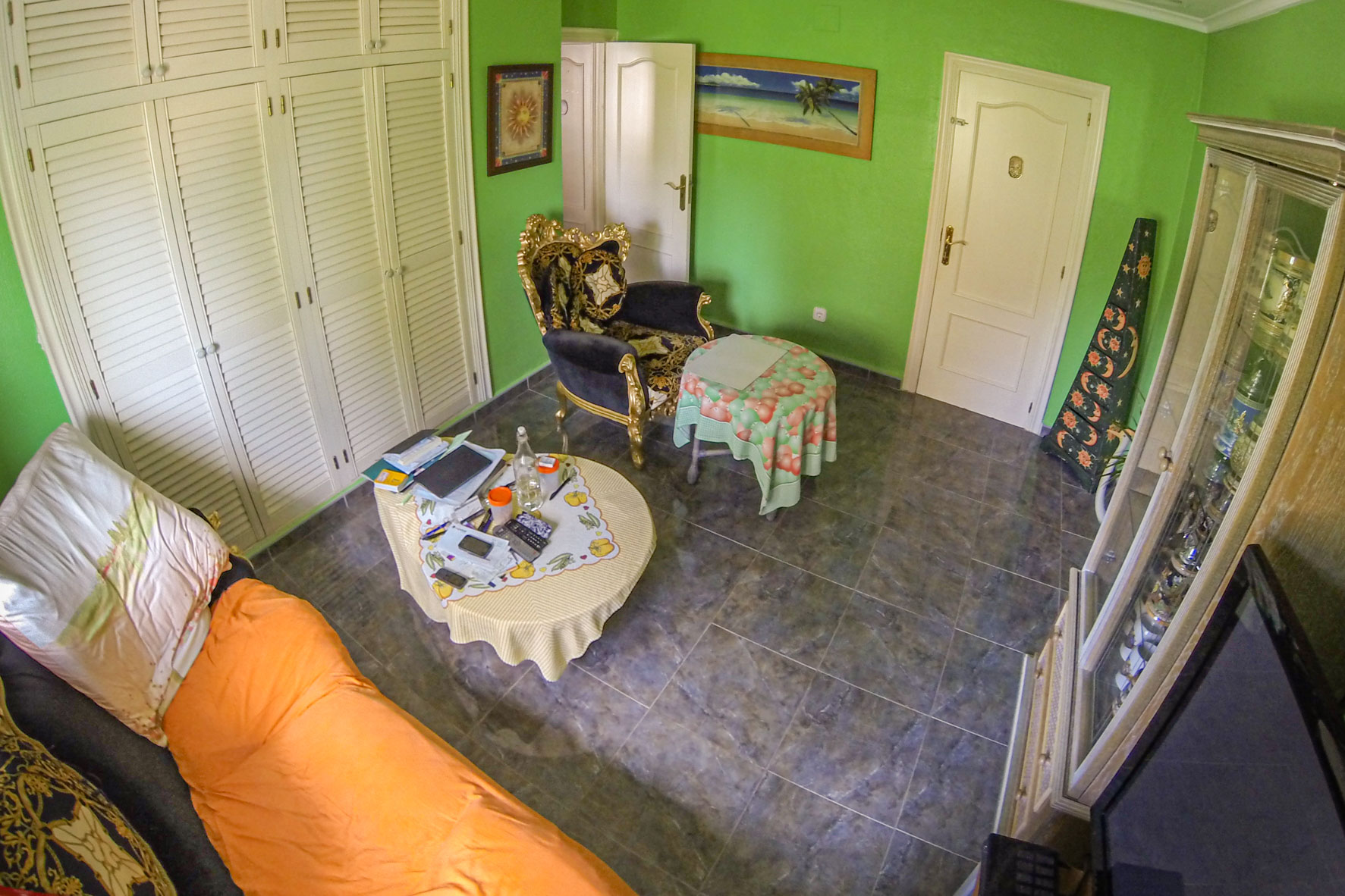Bright room featuring green walls, gray tile flooring, and varied furnishings.