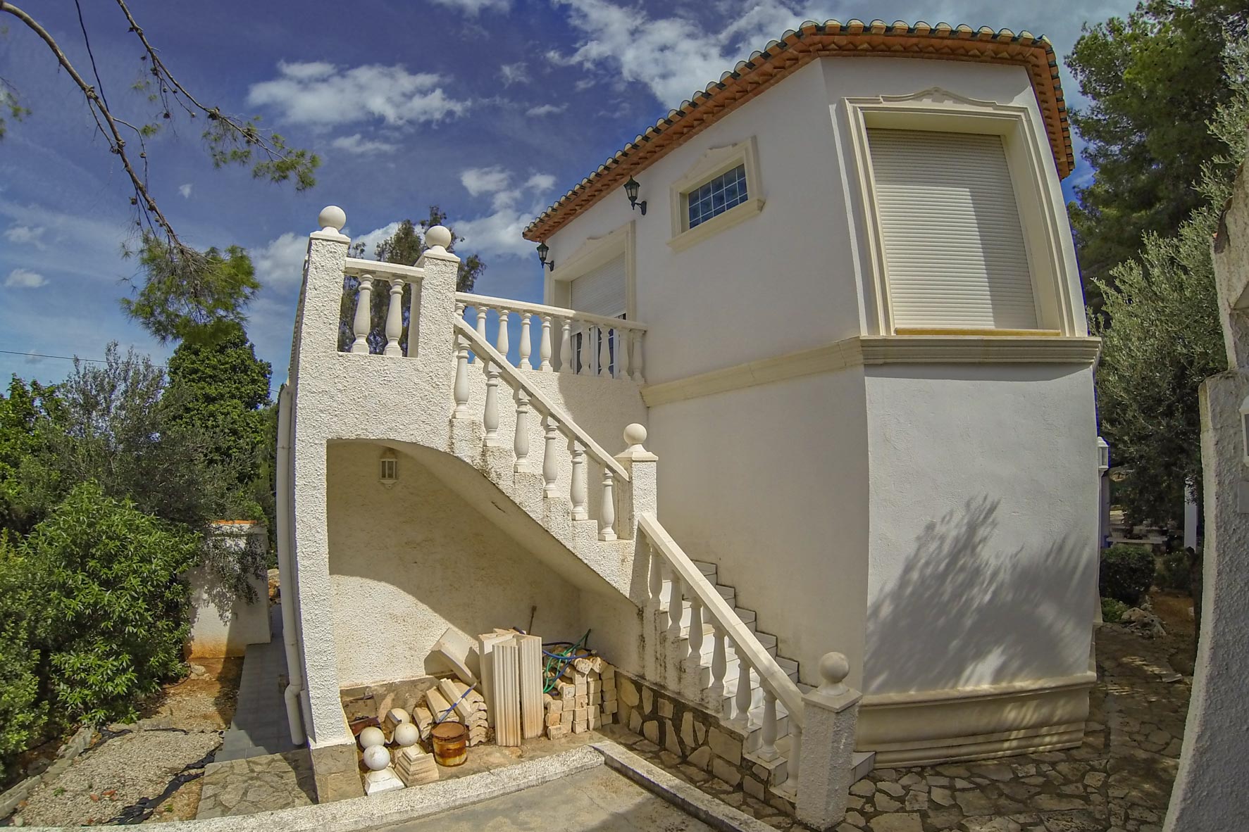 Exterior view of the white stone staircase with balustrade leading to the villa's tower.