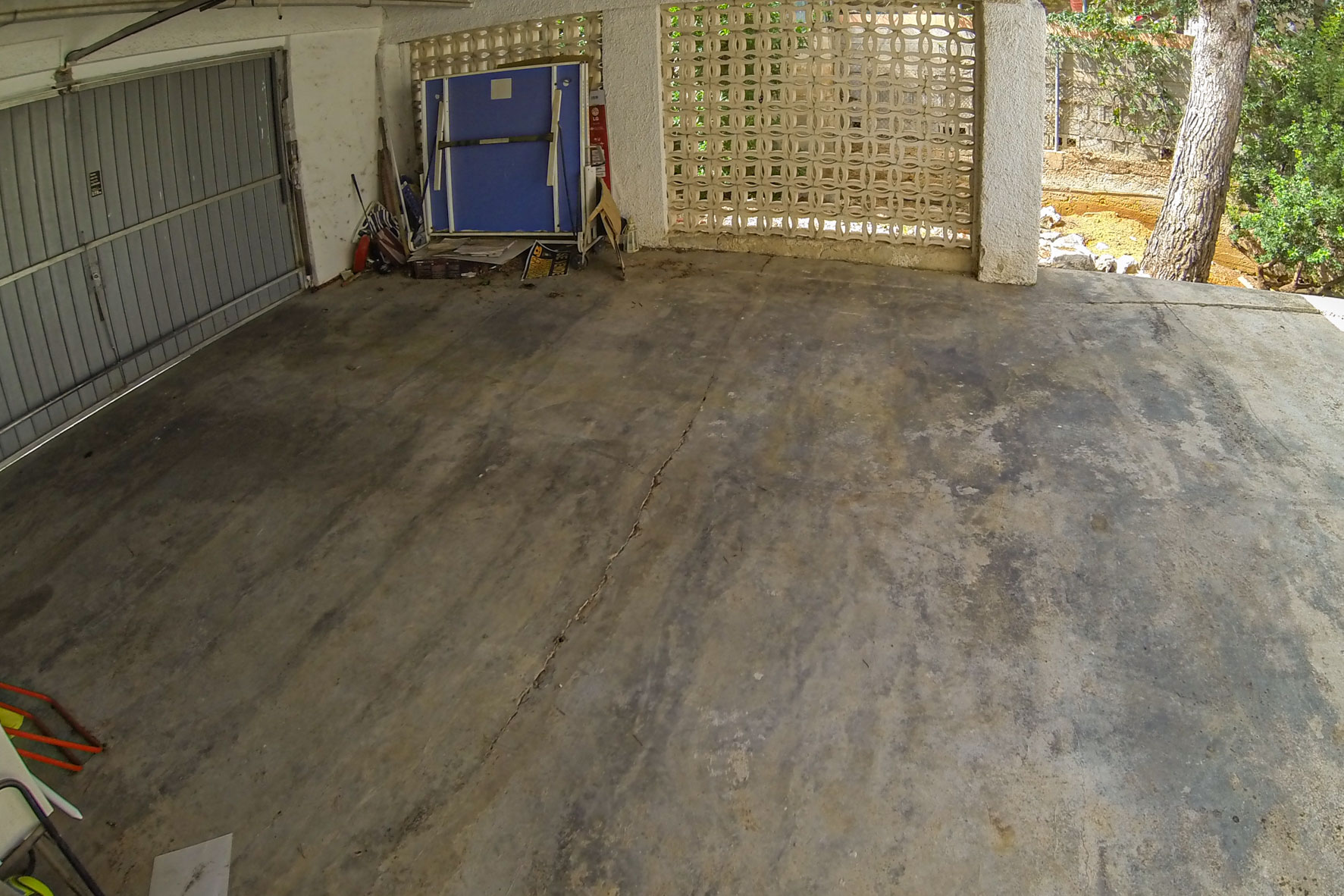 Garage featuring a metal door and a decorative block wall.