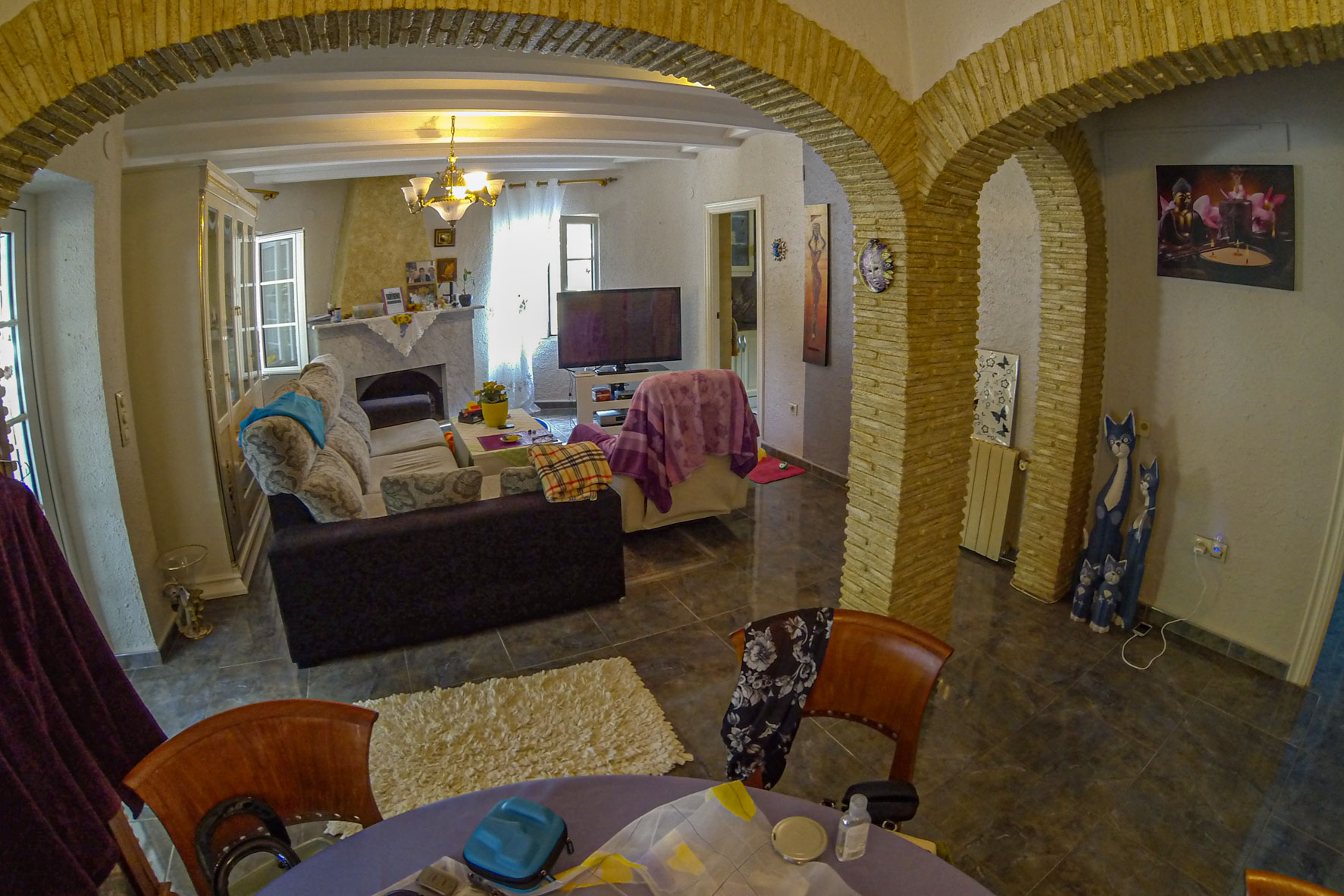 Living room view featuring stone arches, a marble fireplace, and eclectic furnishings.