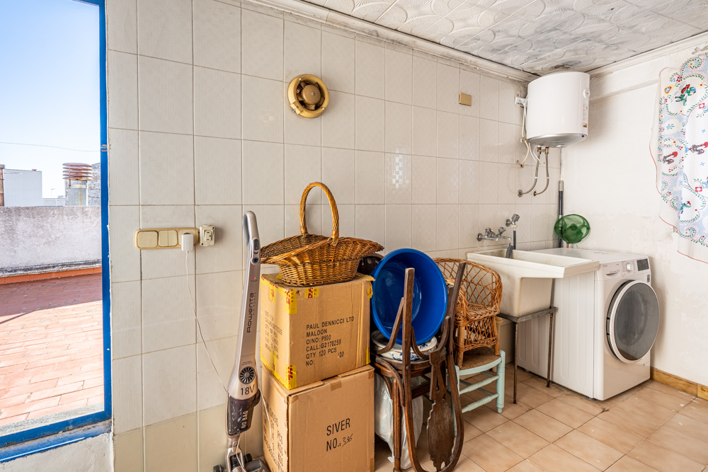 Utility and storage room featuring laundry facilities, an electric water heater, and direct access to the terracotta-tiled roof terrace.