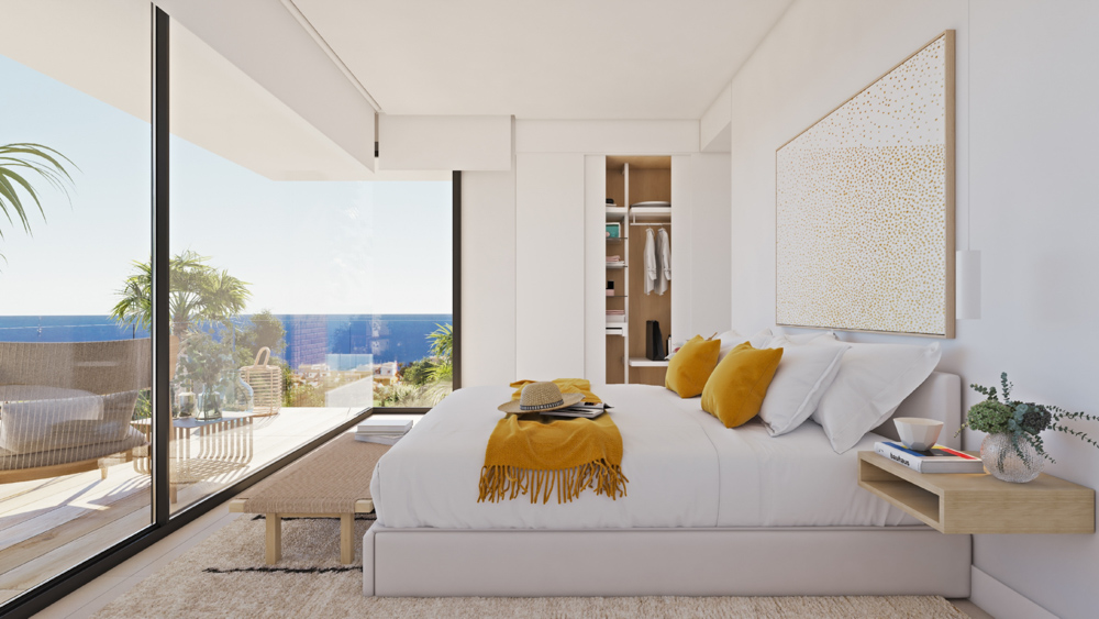 Modern bedroom featuring floor-to-ceiling glass walls with sea views, a built-in wardrobe with oak-toned interior, and minimalist wooden furnishings.