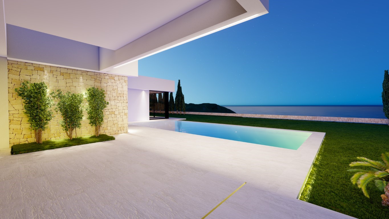 Modern outdoor terrace featuring an illuminated rectangular pool, natural stone accent wall with integrated lighting, and panoramic sea views.
