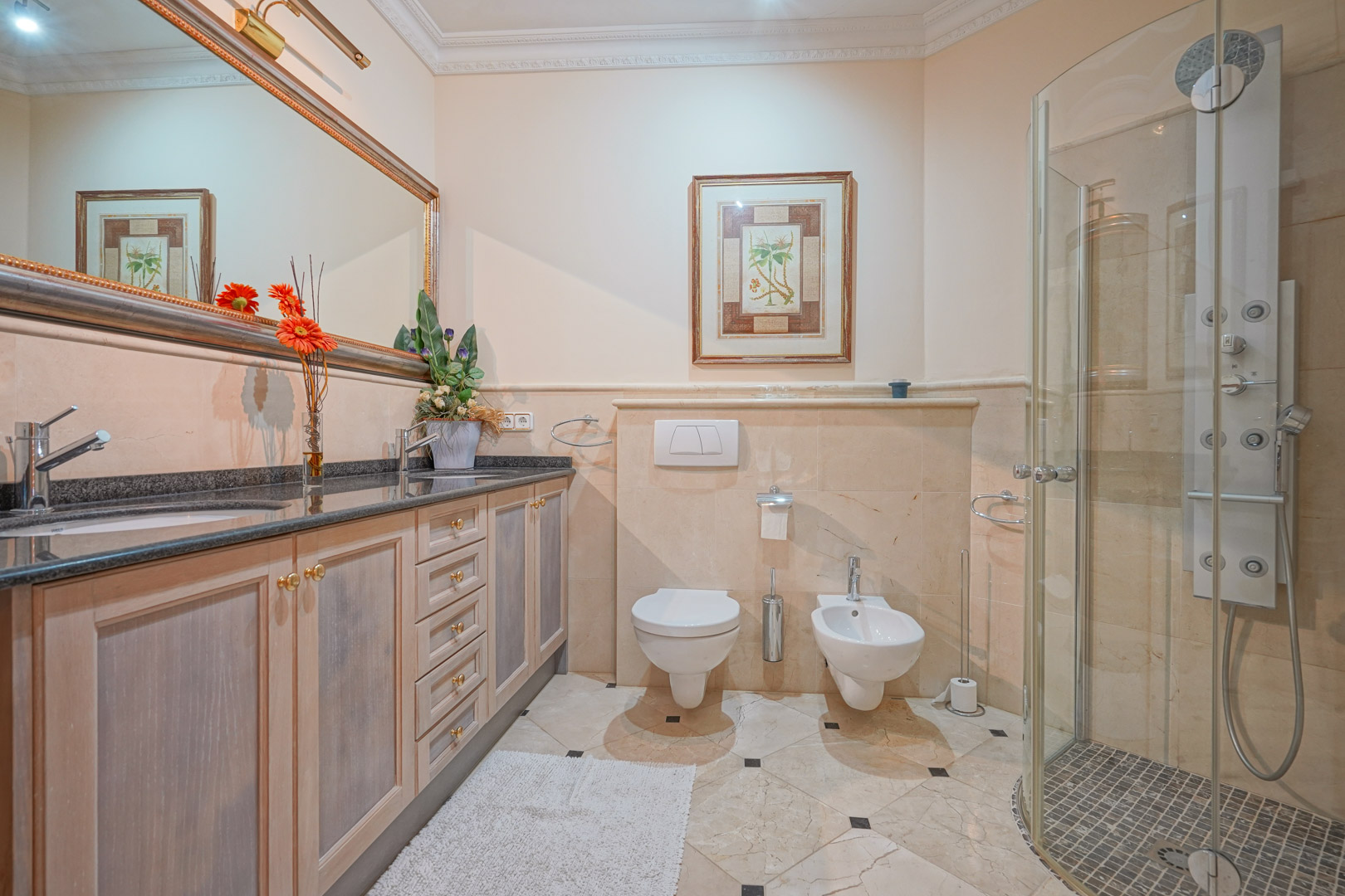 Bathroom featuring a double vanity with granite countertops, wooden cabinetry, and a glass-enclosed shower equipped with a multi-jet hydromassage panel.