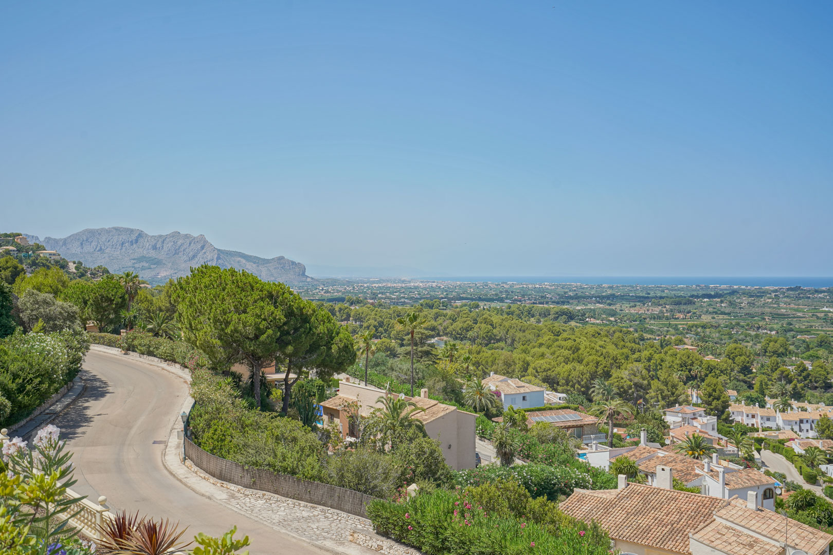Elevated panoramic views overlooking the Mediterranean coastline, the lush green valley, and distant mountain ranges from the prestigious La Sella area.