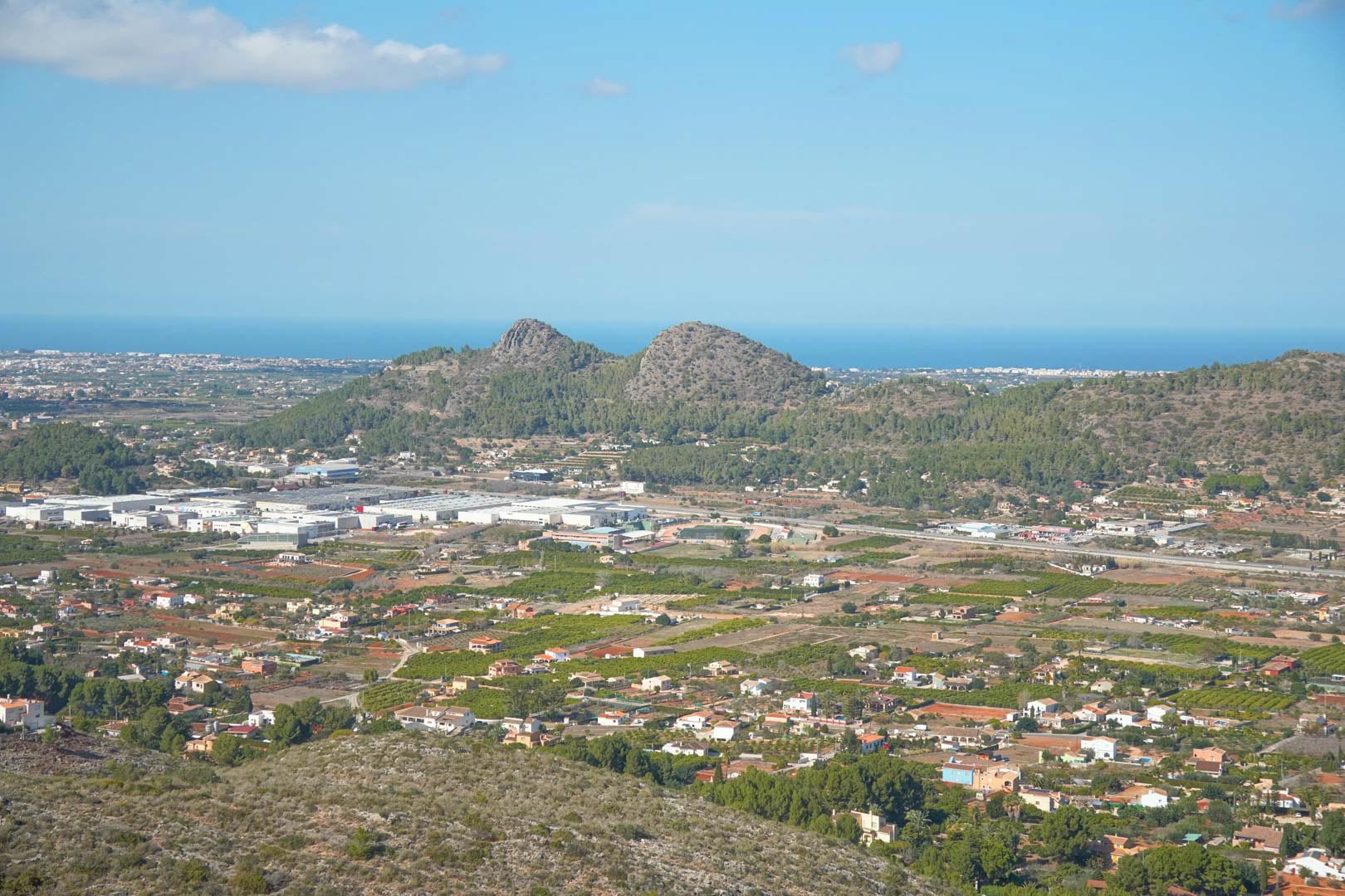 Panoramic elevated view overlooking the lush valley and the Mediterranean Sea horizon, showcasing the unique topography of the Costa Blanca region.