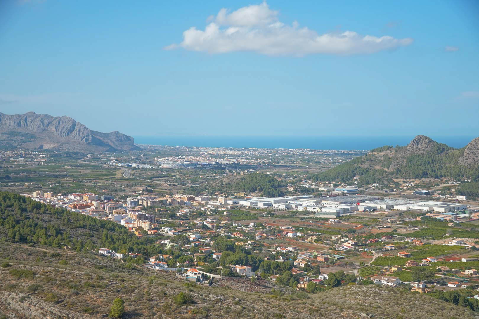 Panoramic views from the property overlooking the valley, surrounding mountains, and the Mediterranean Sea on the horizon under a clear sky.