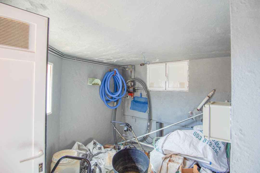 Technical utility room housing the pool filtration system, maintenance hoses, and additional storage space for villa equipment.