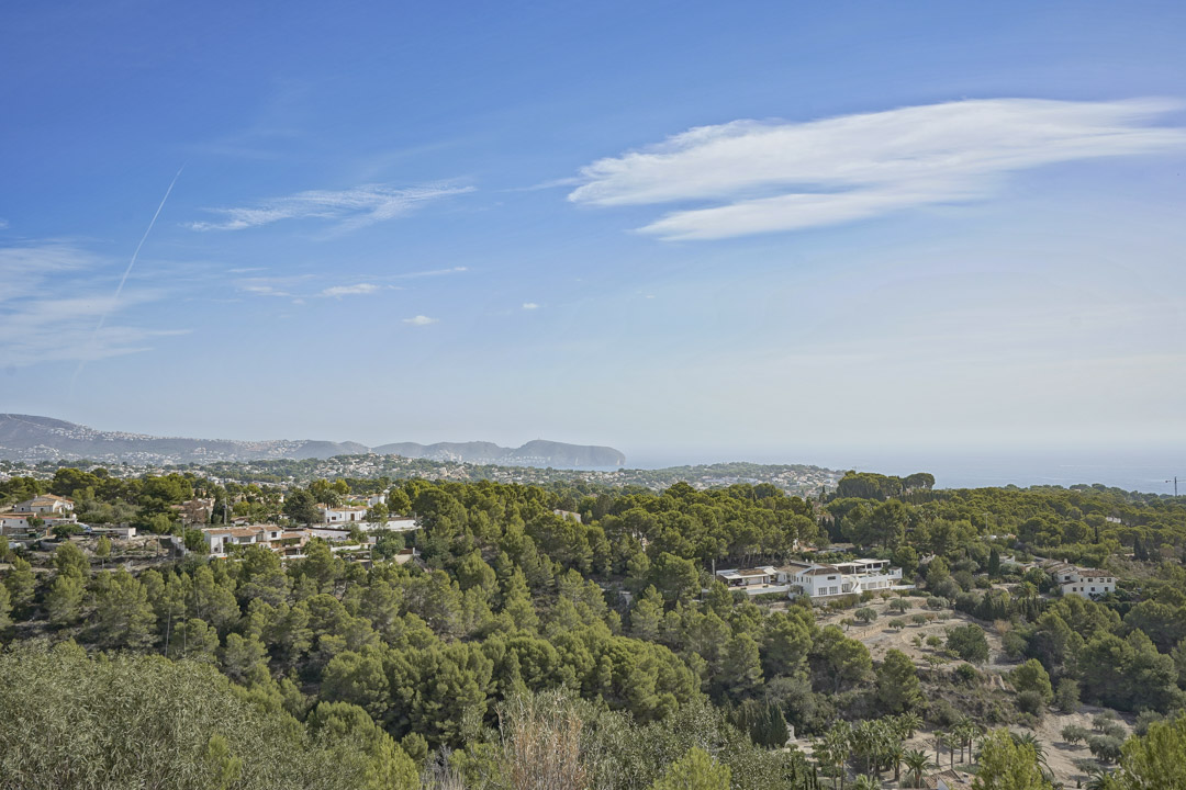 Panoramic coastal view from the property overlooking the Mediterranean landscape, featuring the Cap D'or headland and lush pine forests under a clear sky.