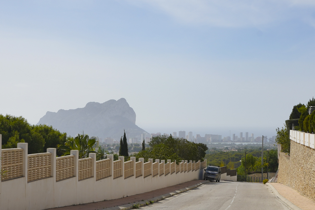 Panoramic view from the access road towards the Peñón de Ifach and Calpe skyline, featuring the Mediterranean Sea in the background.