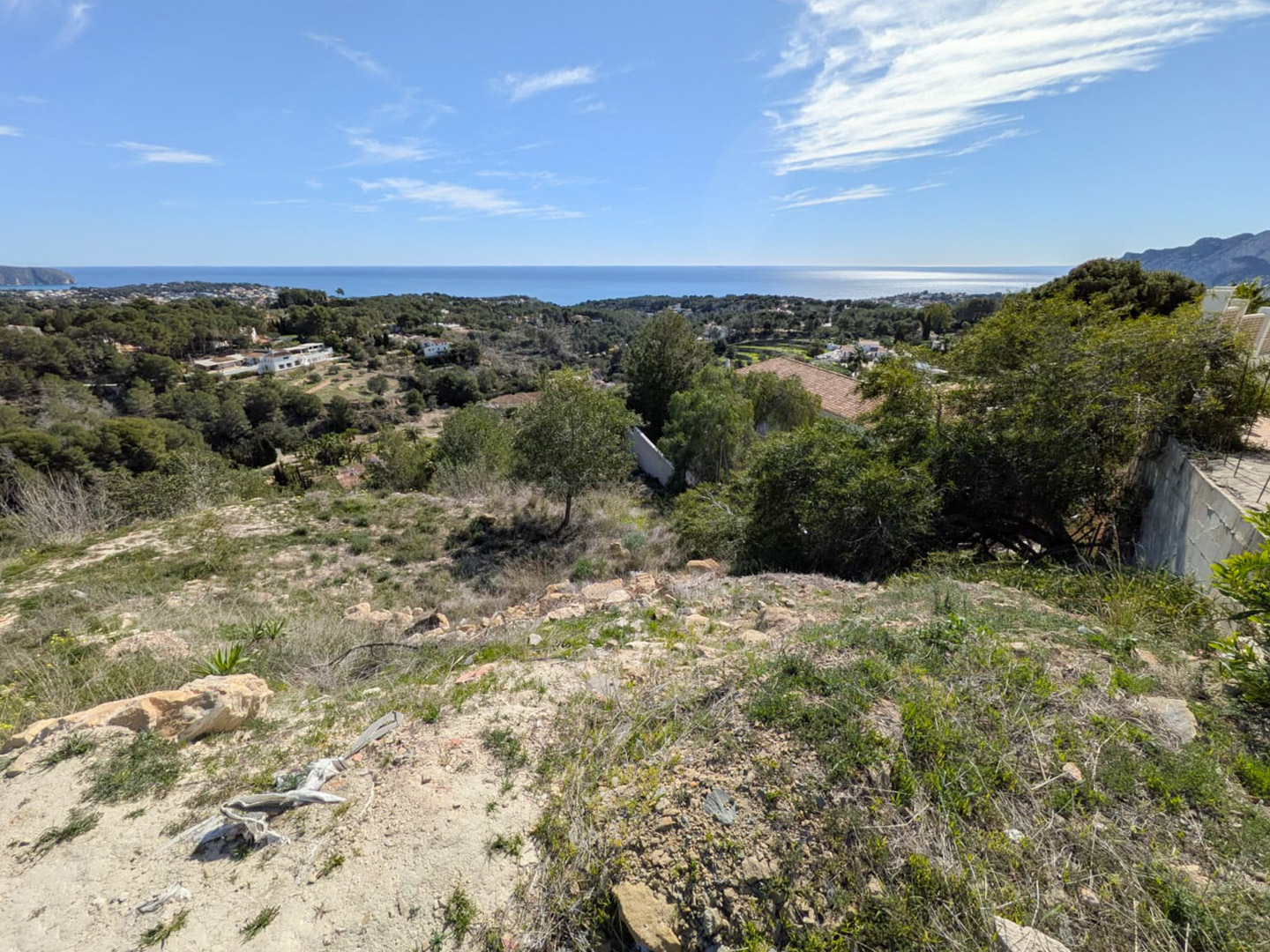 Panoramic view from the elevated plot overlooking the Mediterranean Sea, highlighting the natural steep gradient and surrounding greenery.