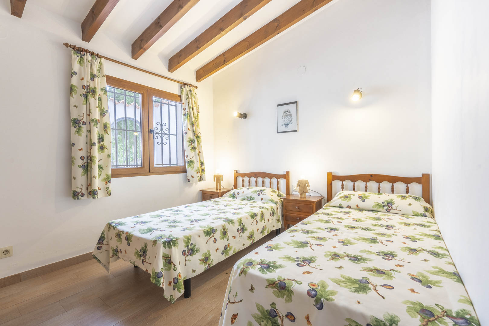Bedroom featuring twin beds, exposed wood beams, and traditional decor.