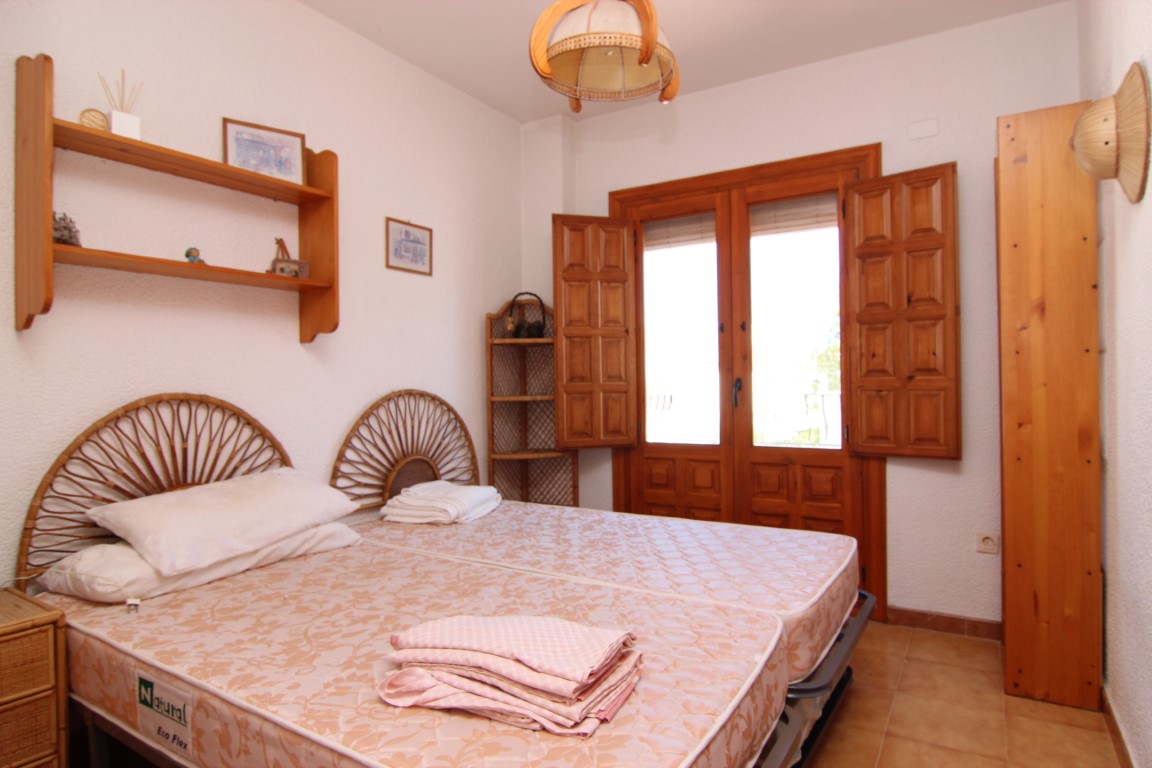 Bedroom featuring twin beds, rattan headboards, and wood carpentry.