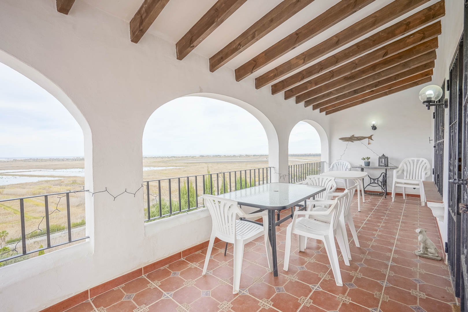Covered terrace featuring panoramic views, wood beam ceiling, and terracotta tile flooring.