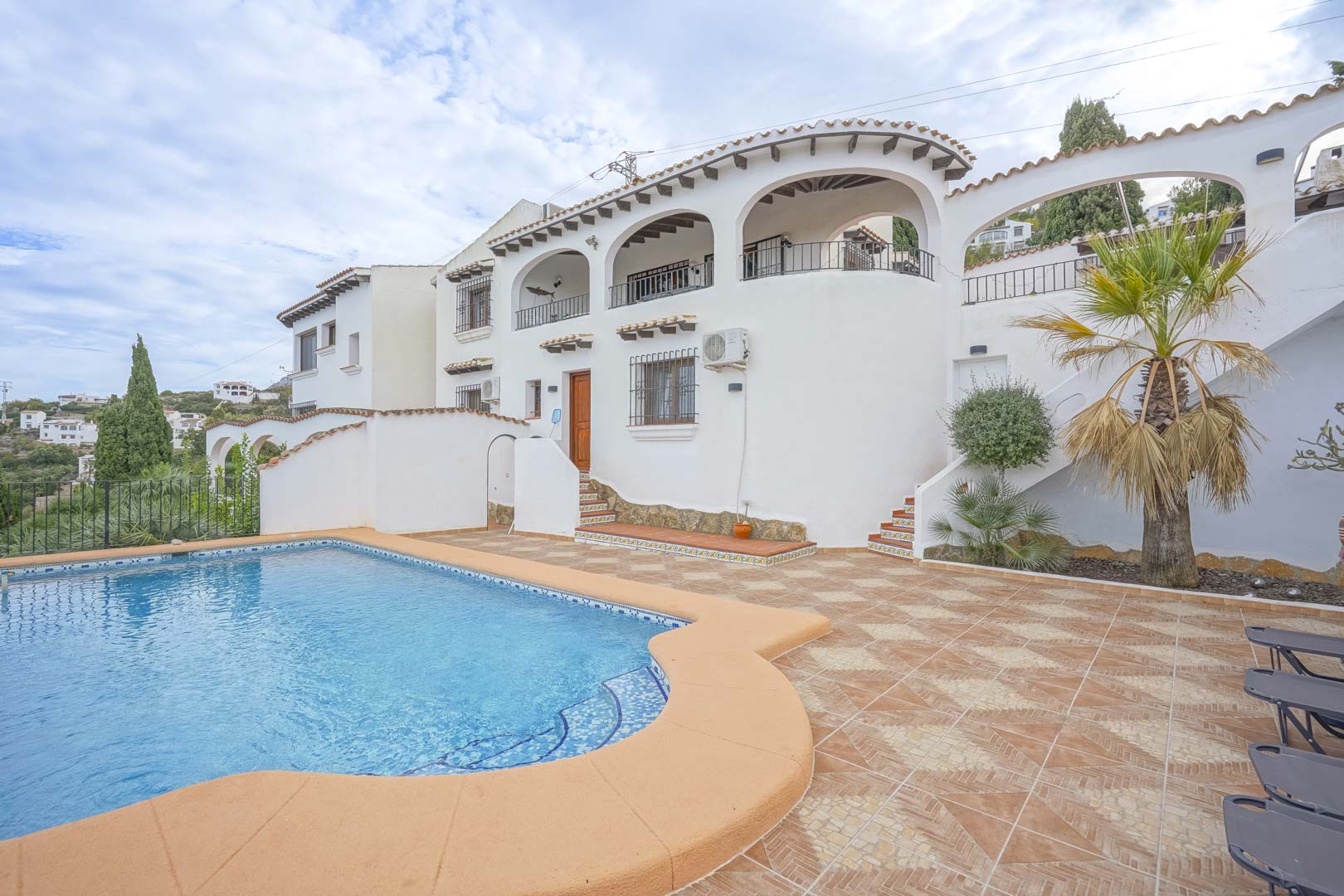 Exterior view of the villa featuring a pool, tiled terrace, and Castilian-style architecture.