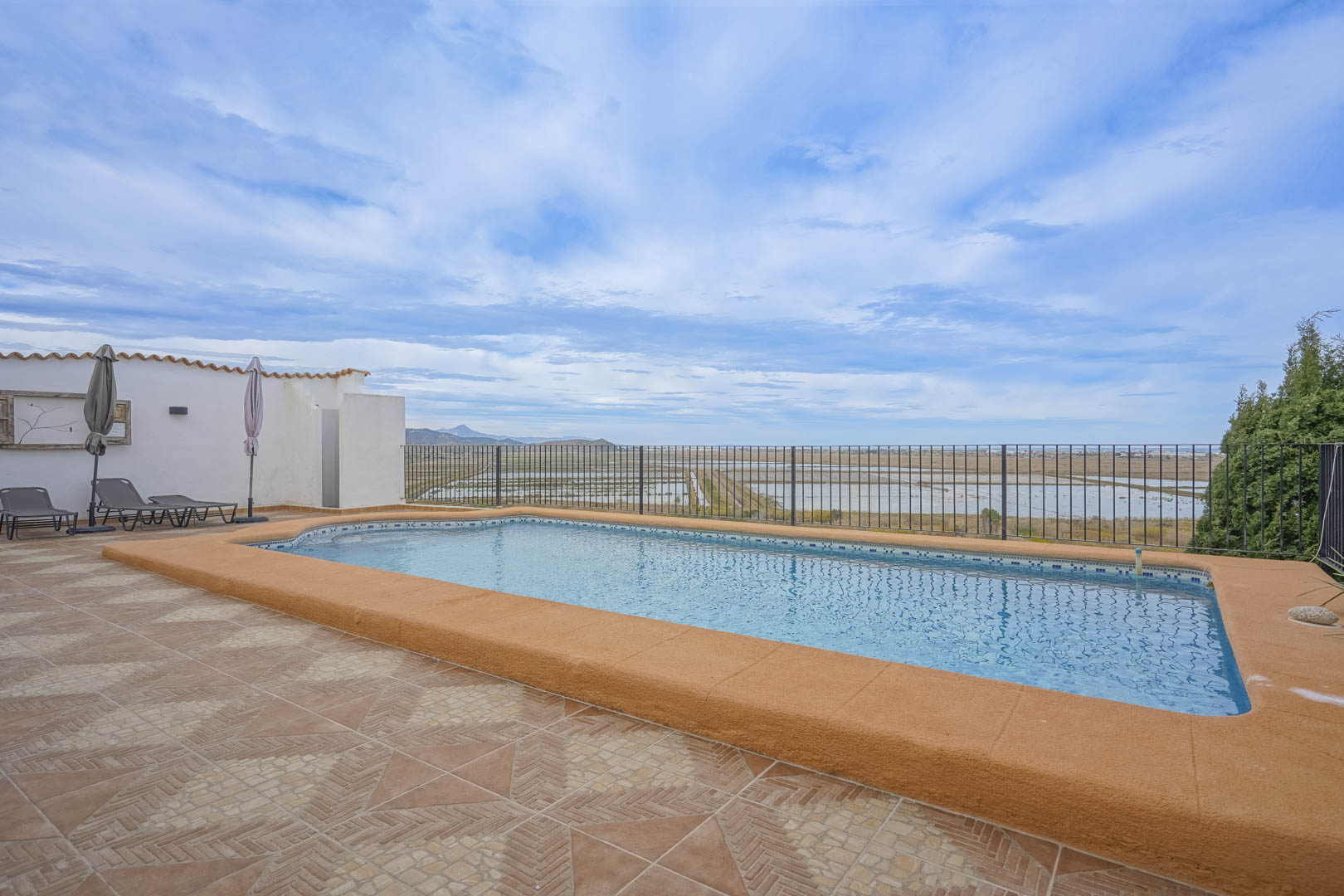 Pool view with ochre border and terracotta tiles, overlooking the nature reserve.