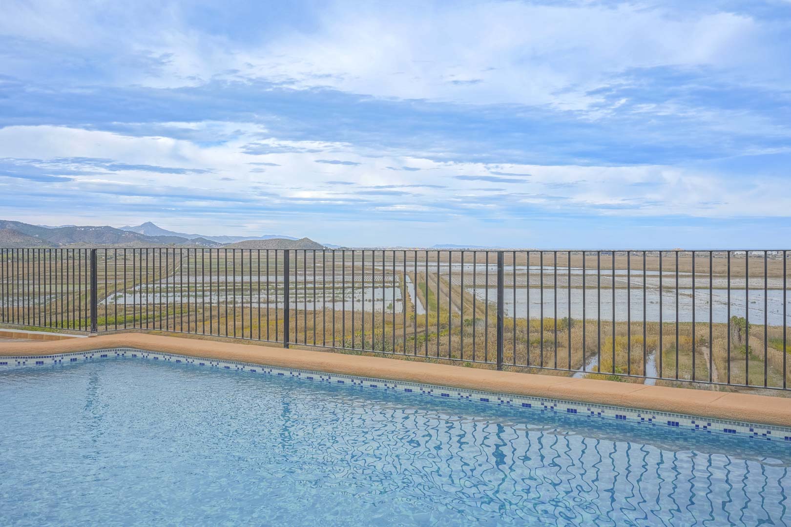 Pool view with railing overlooking the Marjal de Pego landscape.