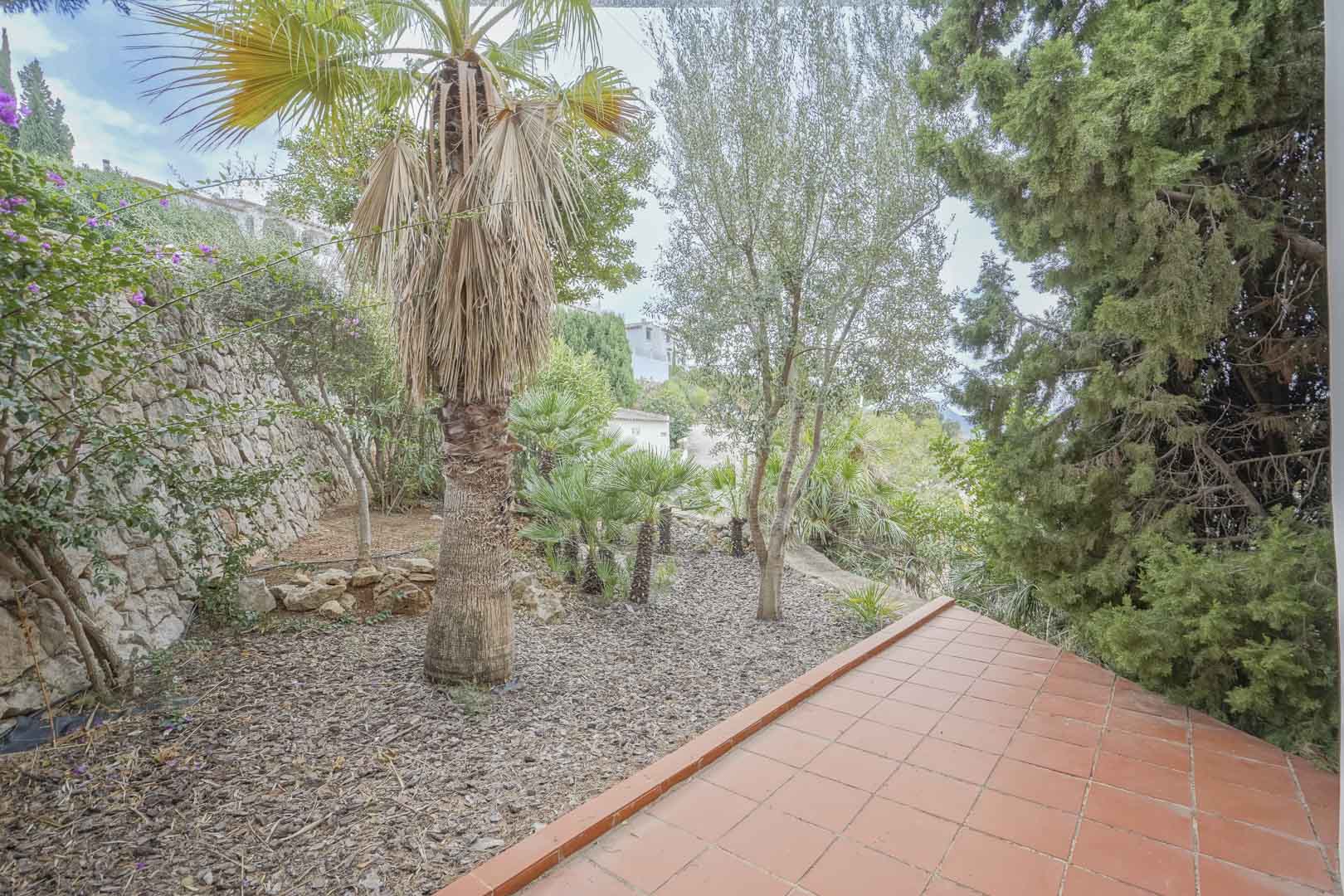 View of the low-maintenance garden with automatic irrigation, as seen from the terracotta-tiled covered terrace.