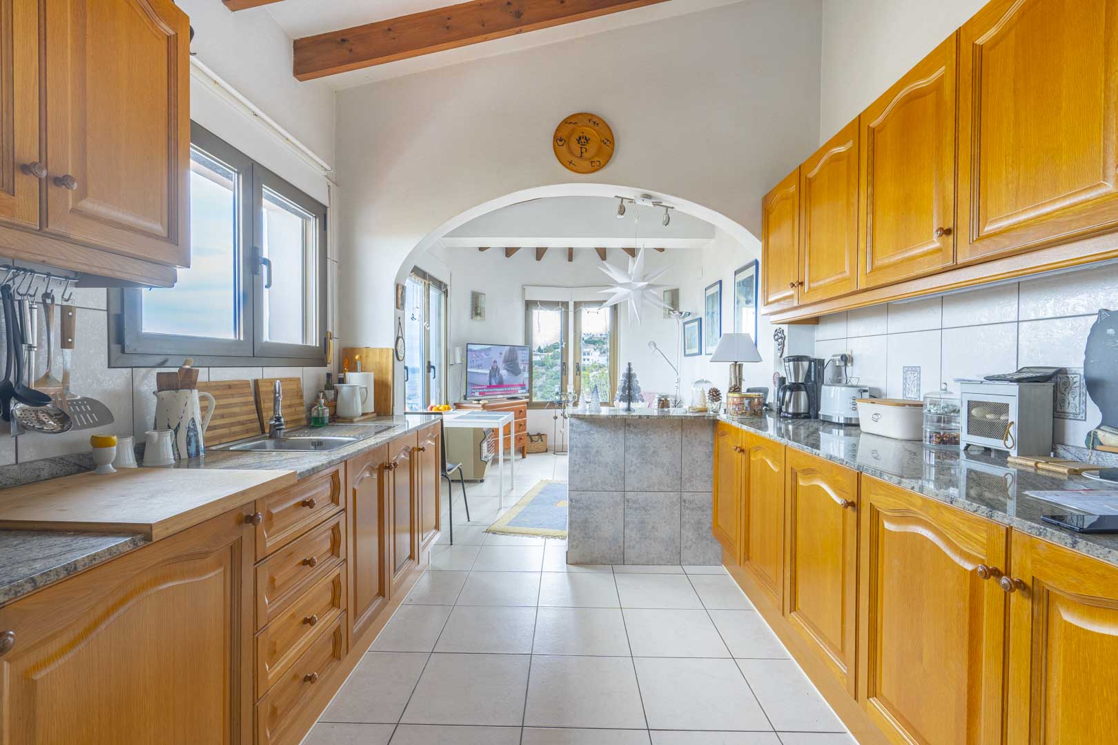 View of the open kitchen featuring granite countertops and wood cabinetry.