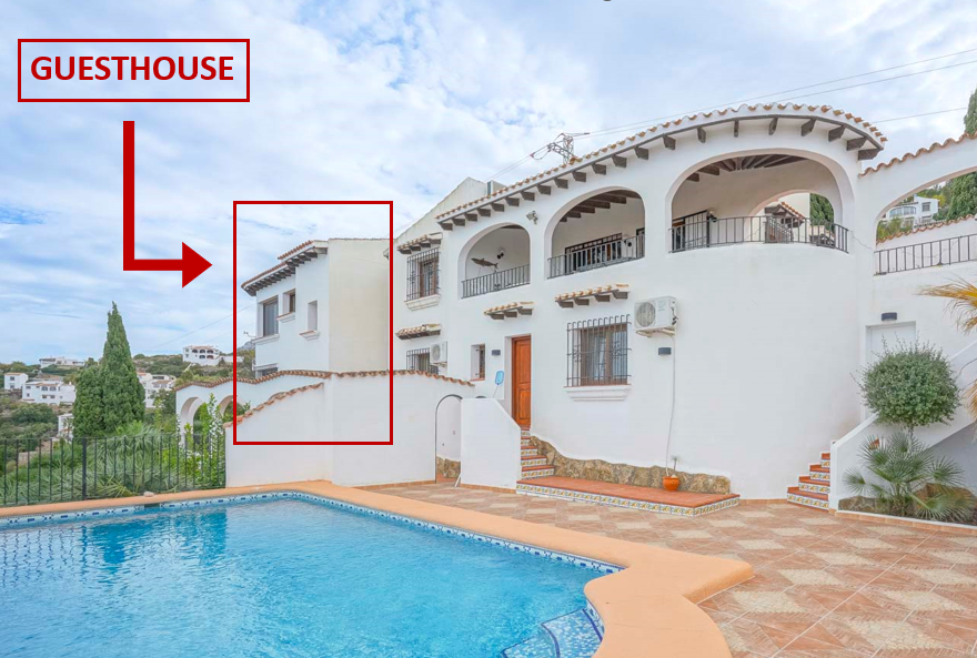 View of the two-story guesthouse with a pool and terracotta tiling.