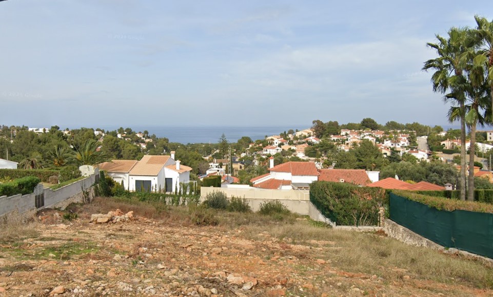 Elevated view of the urbanisation with red-tiled houses and sea views.