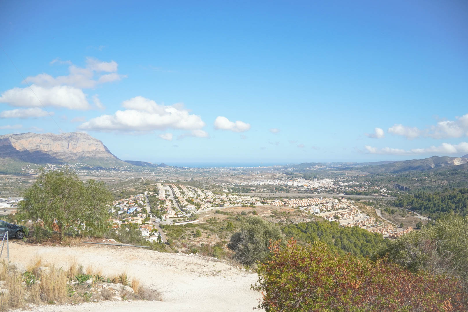 Panoramic elevated view overlooking the Pedreguer valley, featuring the Montgó mountain range and the Mediterranean Sea on the horizon.