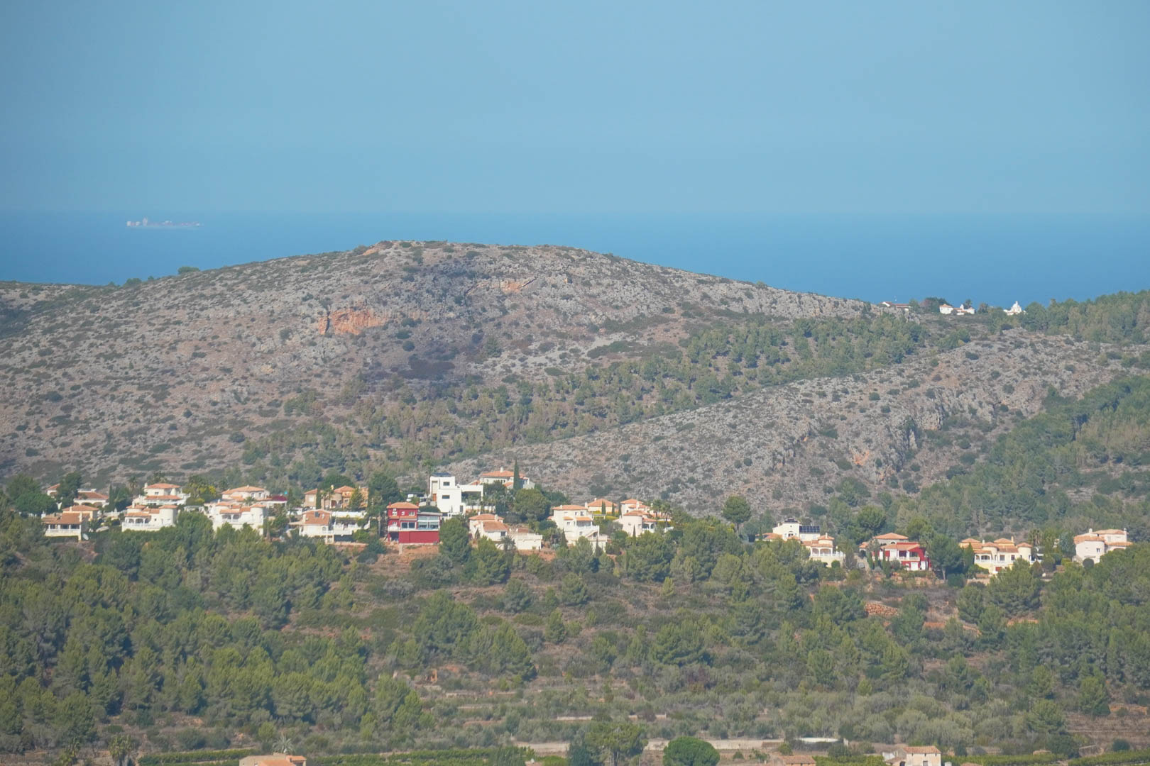 Panoramic view from the property overlooking the Mediterranean Sea and surrounding mountains, featuring residential villas nestled within the pine forest.