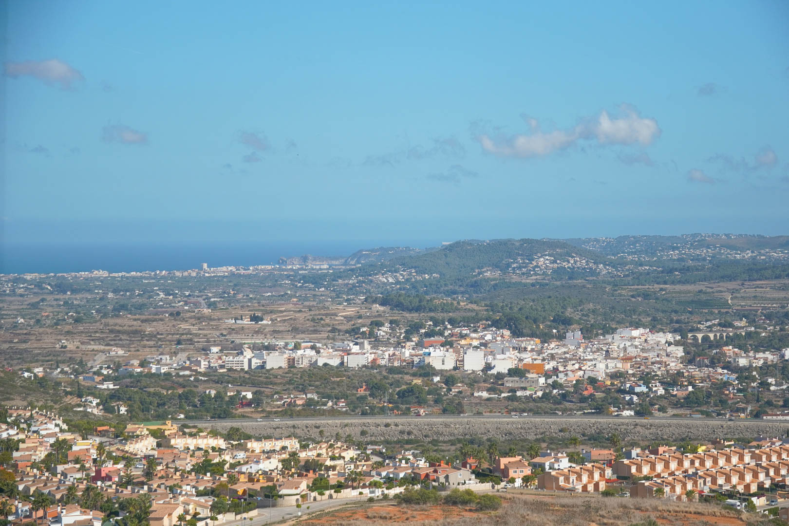 Panoramic views from the property overlooking the Pedreguer valley and the Mediterranean coastline under a clear blue sky.