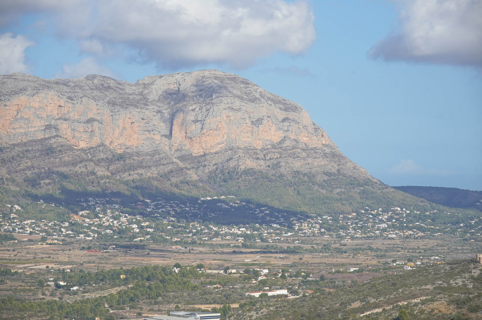 Panoramic views from the property overlooking the valley and the limestone mountain range, highlighting the residential landscape under a bright Mediterranean sky.