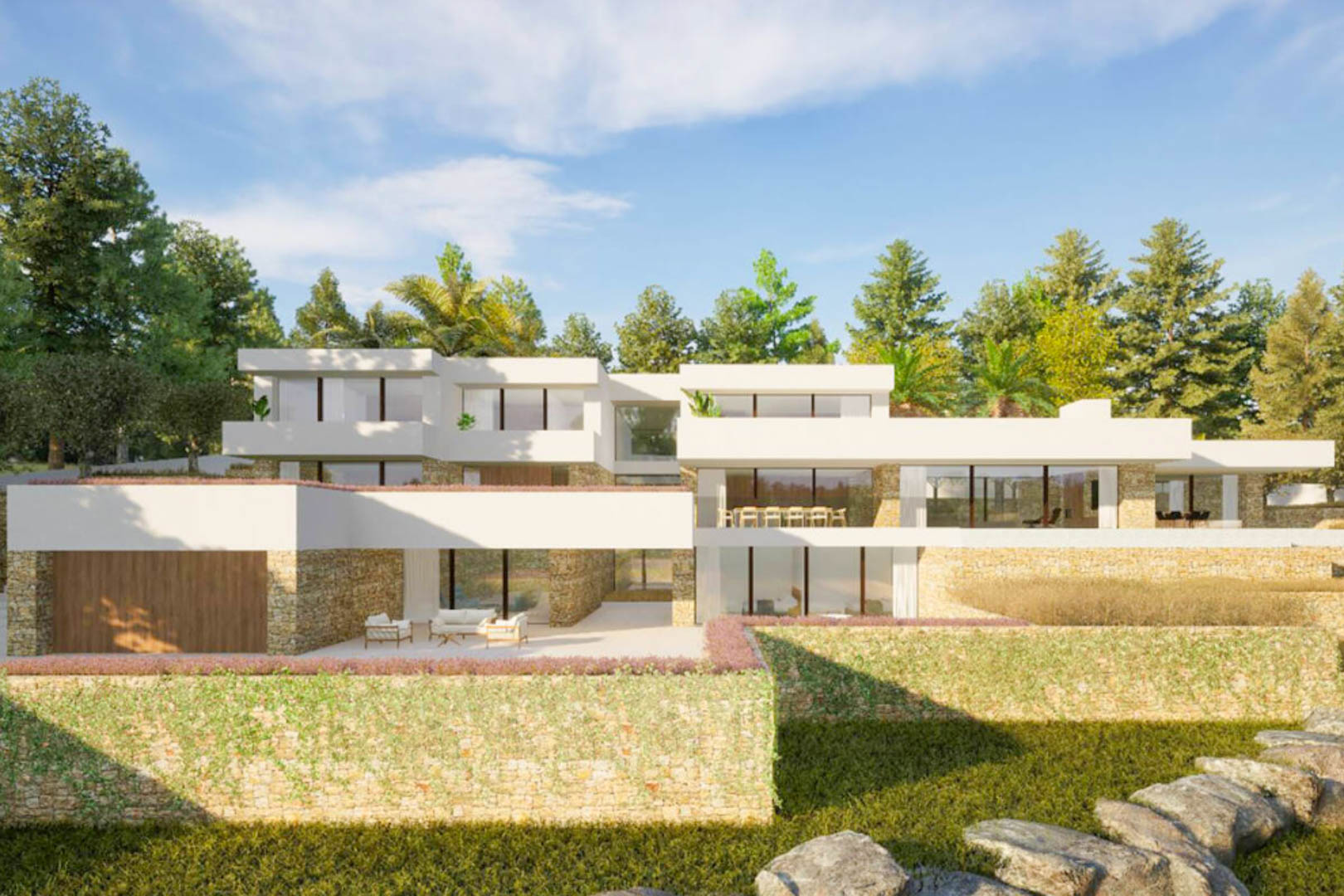 Exterior facade of the villa featuring Ibizan-style architecture, combining natural stone walls, large glass windows, and terraces integrated into a Mediterranean landscape.