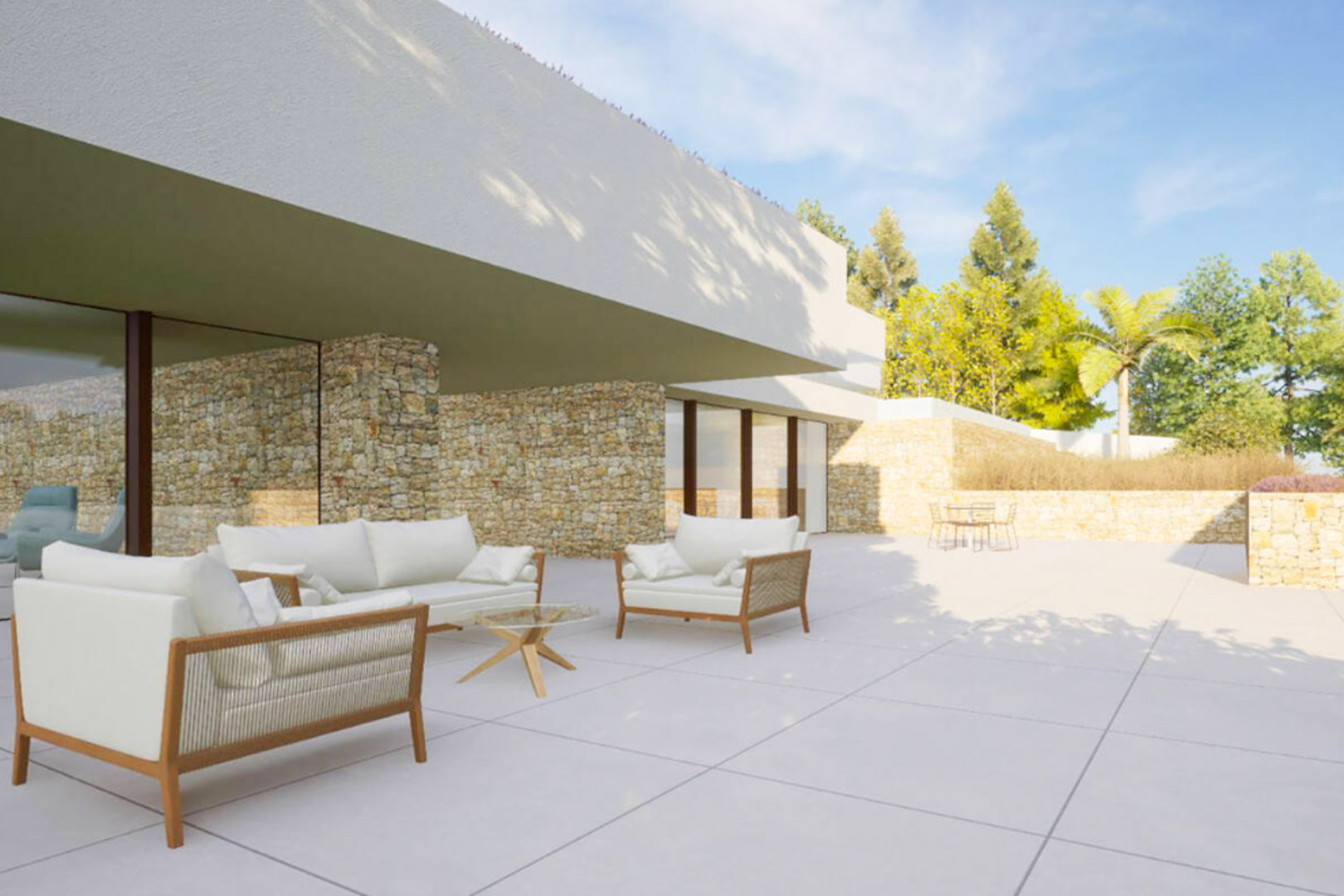 Outdoor terrace featuring designer seating, natural stone walls, and large floor-to-ceiling windows under a modern white cantilevered structure.