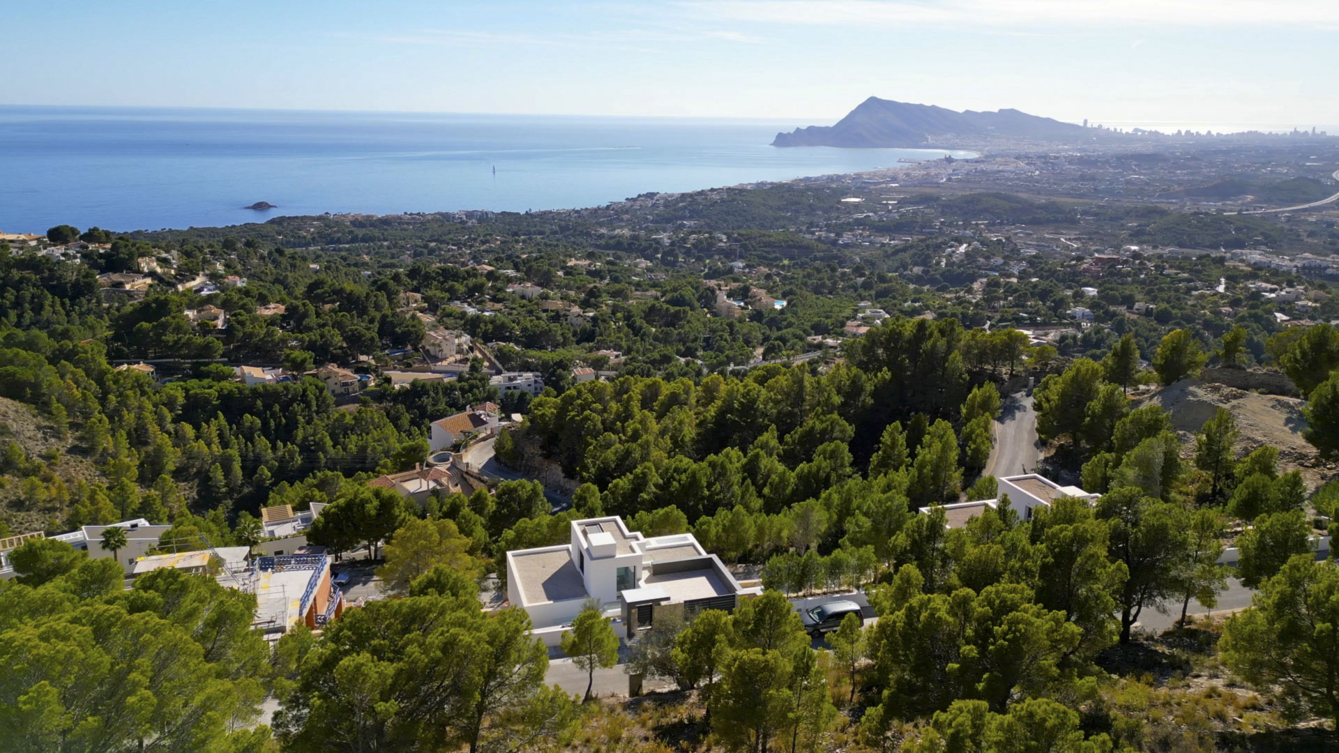 Aerial view of the modern villa in Sierra de Altea, nestled in a pine forest with panoramic views of the Mediterranean Sea and the coastline.