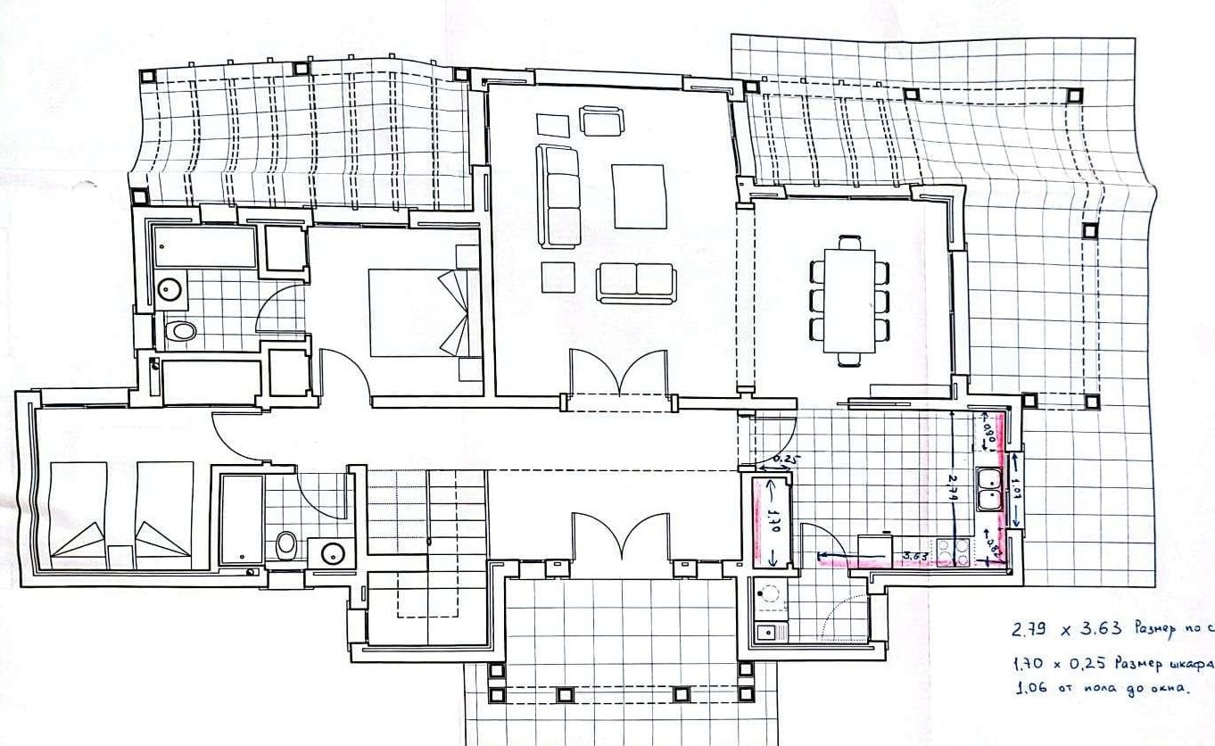 Detailed ground floor plan illustrating the layout of the living-dining area, kitchen with technical dimensions, and two bedrooms with bathrooms.
