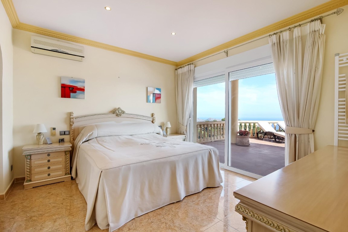 Master bedroom with direct terrace access, ceramic tile flooring, air conditioning, and large sliding doors overlooking the Mediterranean Sea.