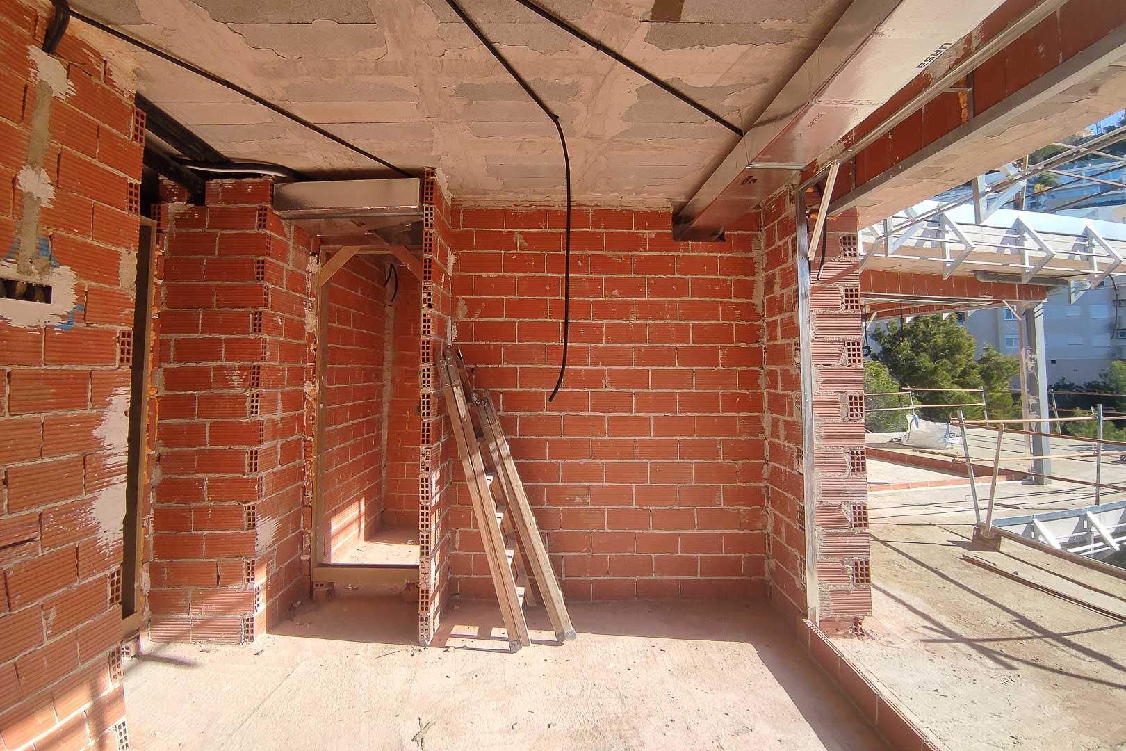 Construction progress showing brick partitions, concrete ceilings, and the installation of HVAC ductwork and electrical systems in the Altea villa.