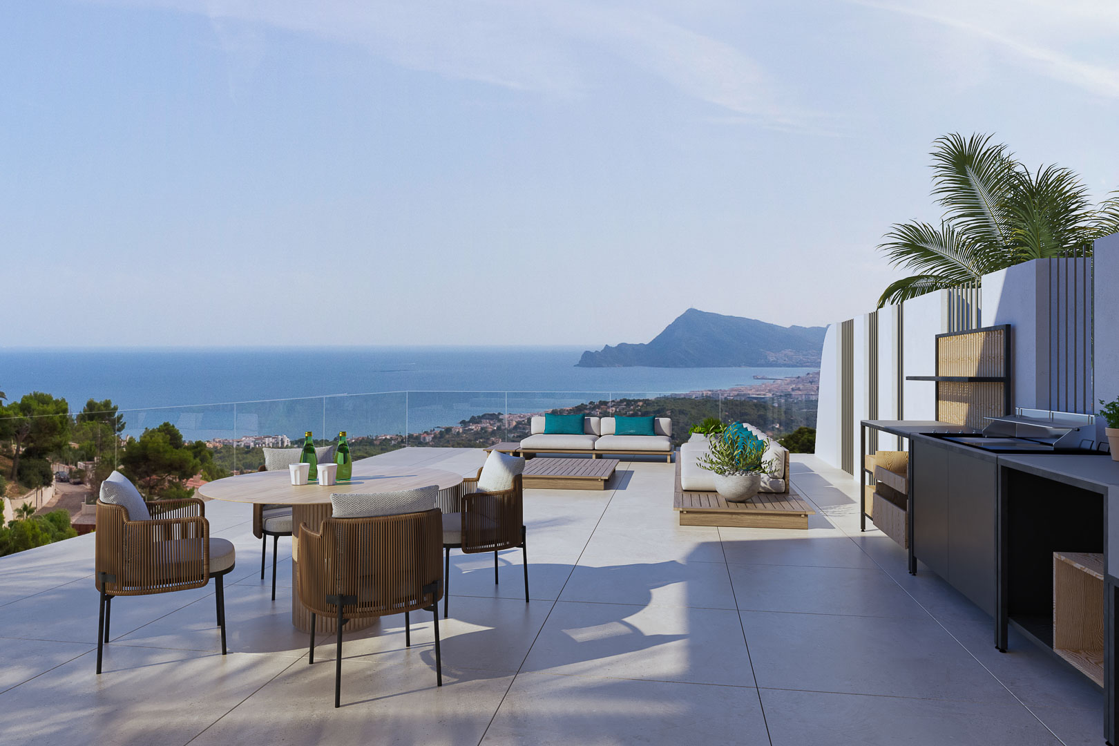 Panoramic terrace featuring an outdoor kitchen, dining area, and lounge. Clear sea and mountain views with glass railings and large-format porcelain flooring.