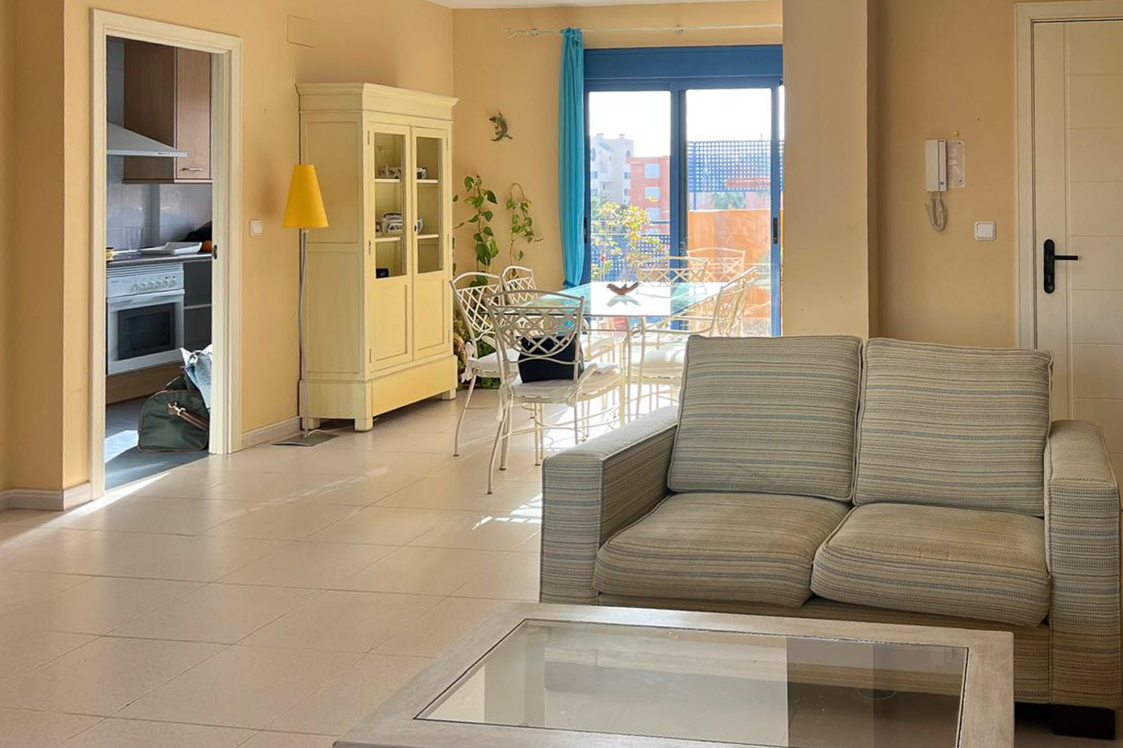 Bright living room with upholstered sofa, coffee table, and terrace access.