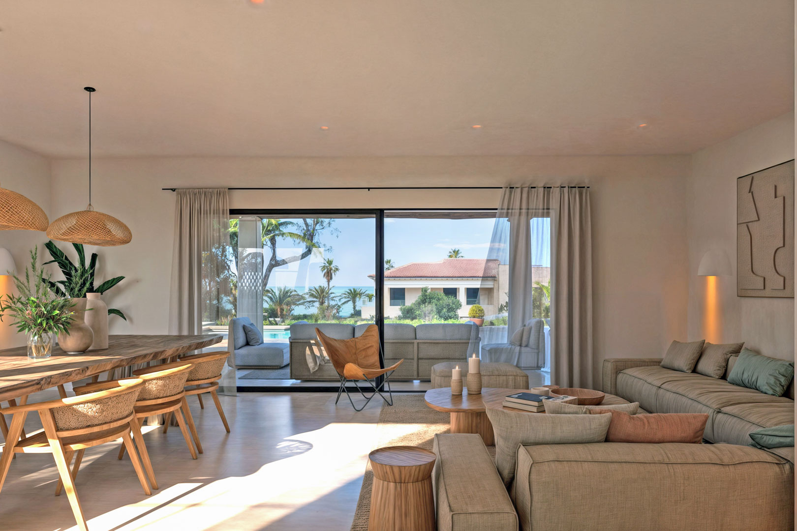 Bright living-dining area with terrace access and sea view. Wooden furniture and neutral textiles.