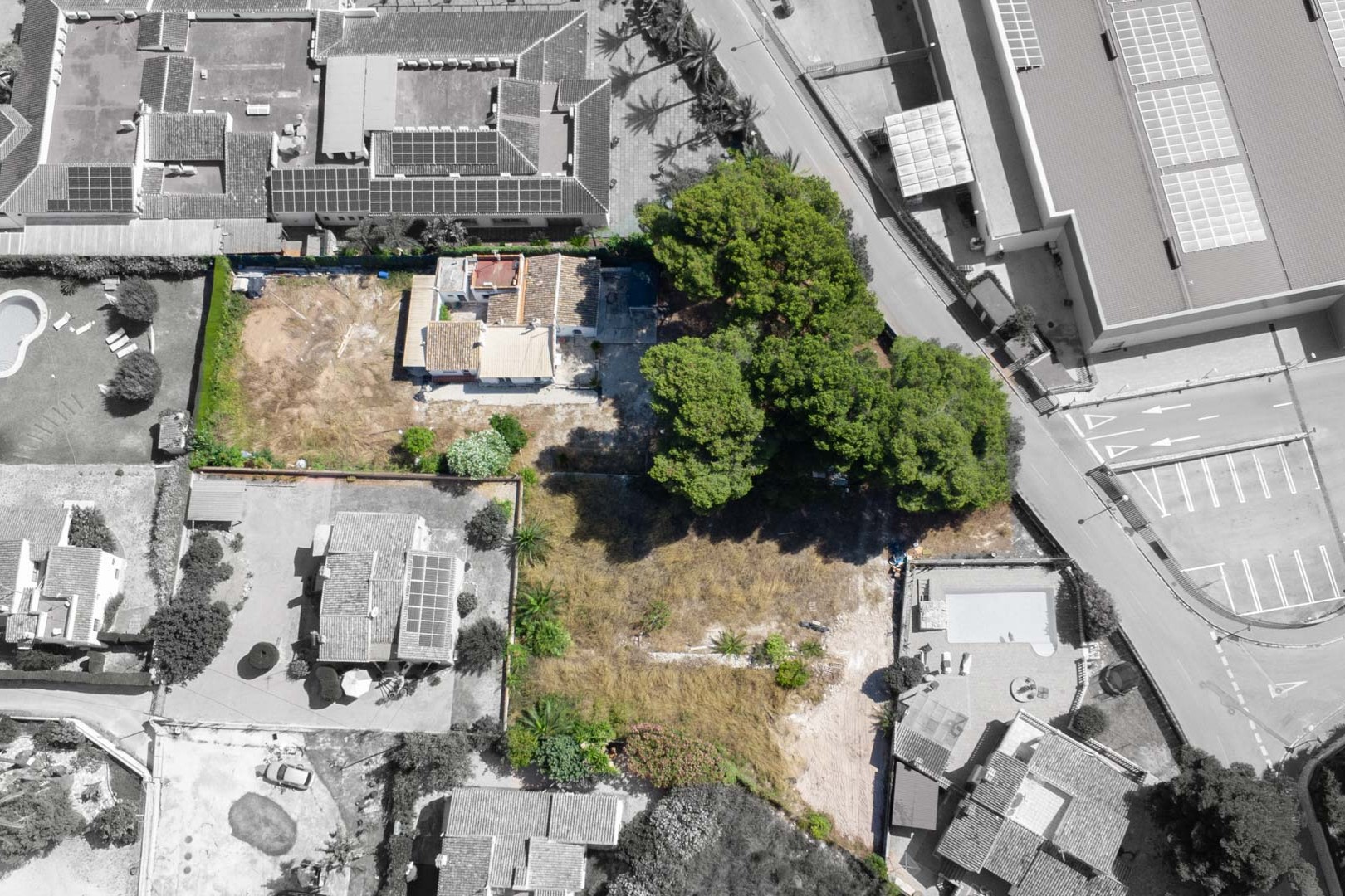 Overhead aerial view of the 2,600 m² plot, featuring the existing villa, mature pine trees, and its strategic location within a developed residential area in Jávea.