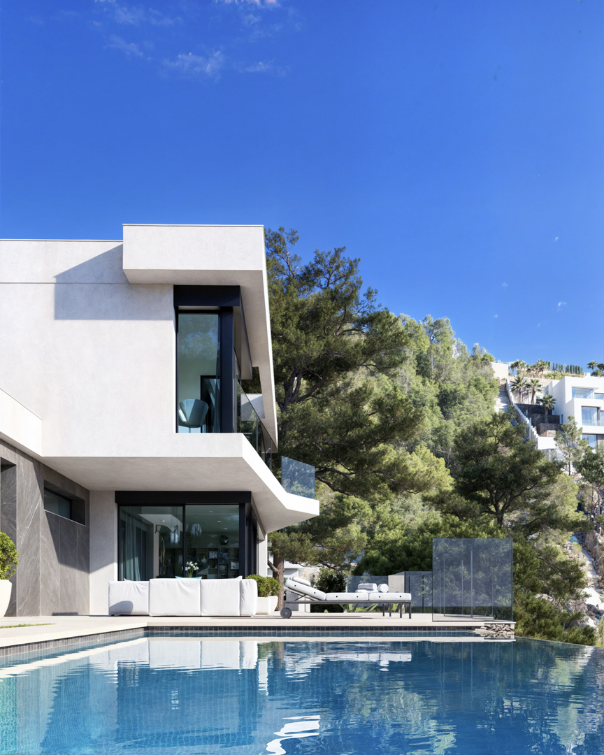 Exterior view featuring an infinity pool, minimalist white and grey stone facade, and large glass windows overlooking a lush pine-covered hillside.