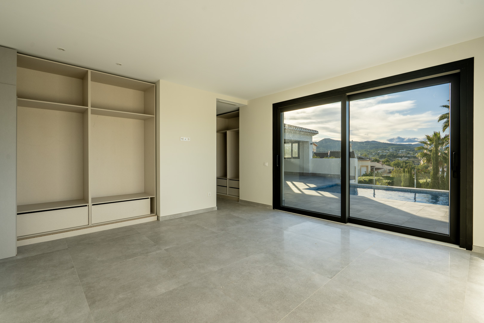 Bright bedroom featuring built-in closet and sliding glass door access to the pool area.