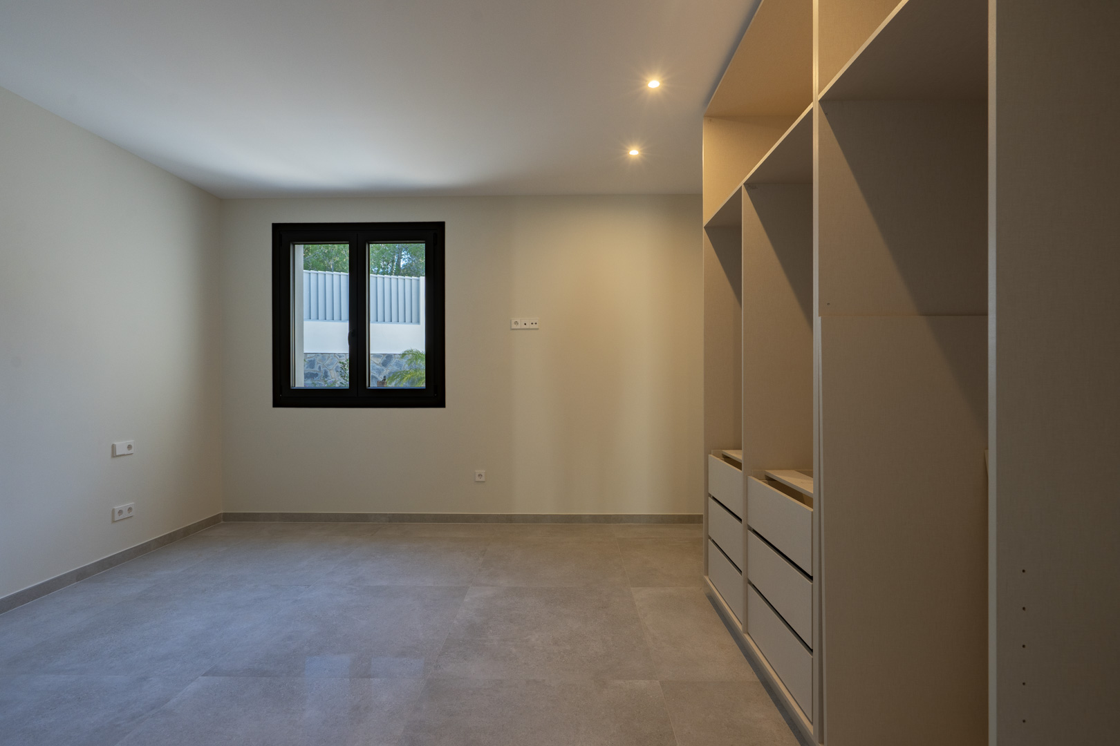 Bright interior featuring a built-in wardrobe and a black-framed window.
