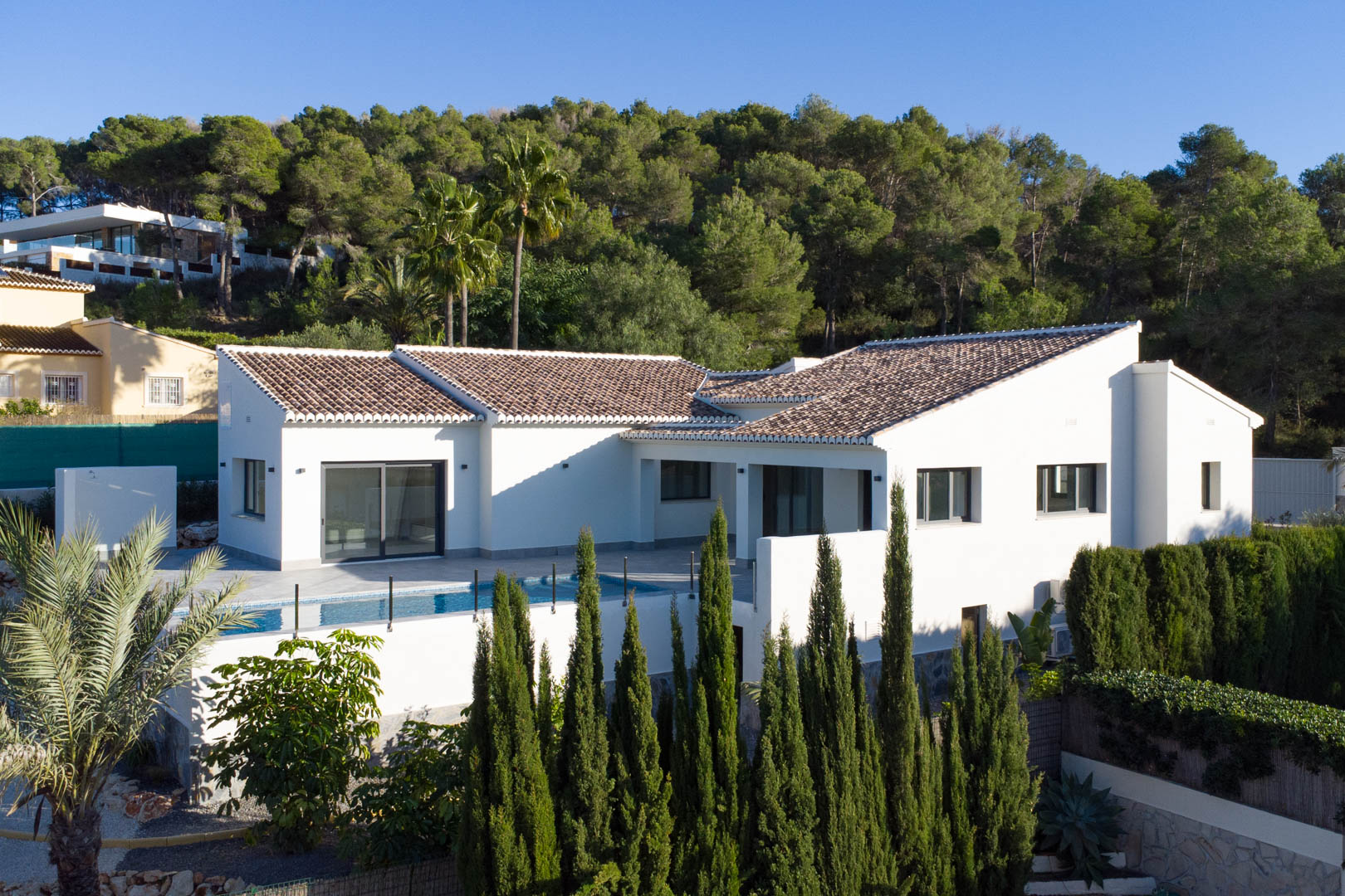 Exterior view of the villa in Piver, Jávea, showcasing its modern design, private pool, and lush natural surroundings.