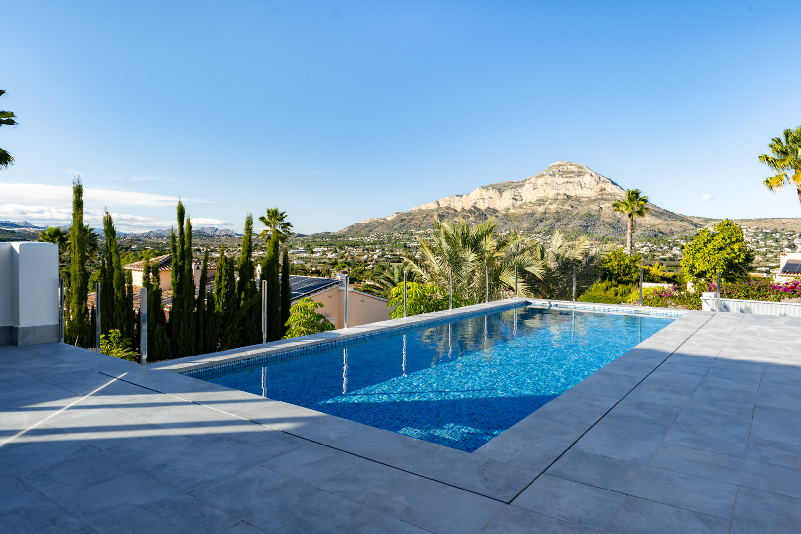 View of the private pool with blue tiles and gray border, featuring panoramic views of the mountain and landscape.