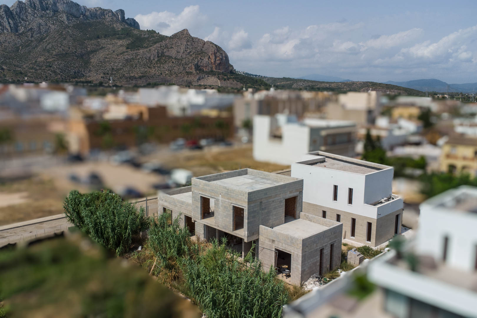 Elevated view of the villa's concrete block structure under construction, set against the Segaria mountain range in El Vergel.